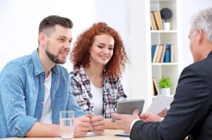 An agent discussing small business health insurance options with a couple in Grand Rapids, MI
