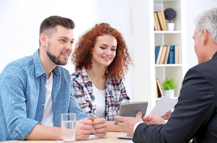 An agent discussing small business health insurance options with a couple in Grand Rapids, MI