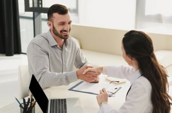 Client shaking an agent's hand after signing up for individual health insurance in Grand Rapids, MI
